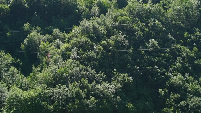 Man cross over the river by zipline in green nature