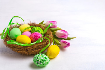 Easter eggs in the nest, tulips and silk ribbon