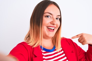 Beautiful woman wearing striped t-shirt and jacket standing over isolated white background very happy pointing with hand and finger