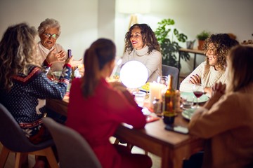Beautiful group of women smiling happy and confident. Eating roasted turkey celebrating christmas at home