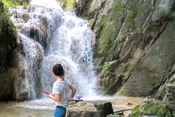 young cute hipster girl travelling at beautiful Erawan waterfall mountains  green forest hiking views at Kanchanaburi, Thailand. guiding  idea for female backpacker woman women backpacking