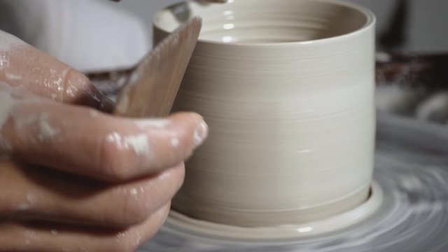 Moulding a clay pot on wheel