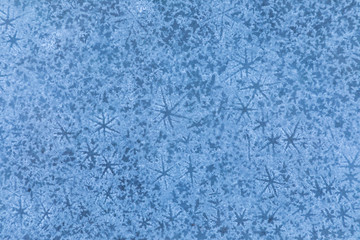 The macro or closeup shot of ice texture or background  with stars on the puddle or pool in the frost winter weather
