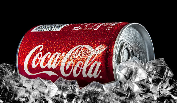 Can of Coca-Cola on a bed of ice over a black background