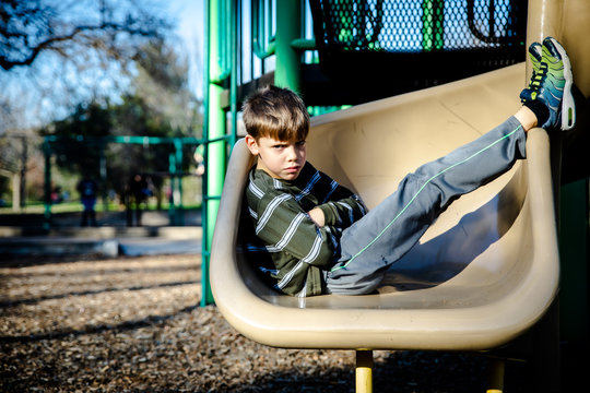 Angry Boy On Playground Slide