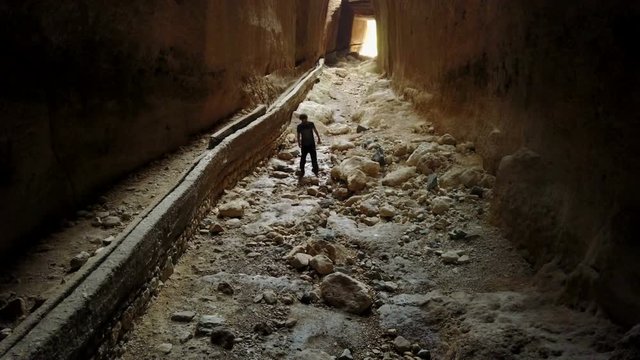 Man hiking thru the darkness in Vespasianus Titus Tunnel, Antakya
