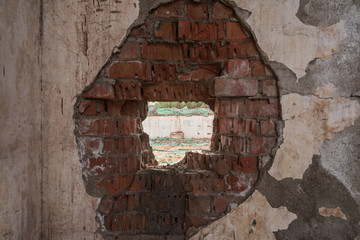Smashed hole in retro red brick wall
