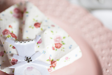 Pink themed festive wedding table setting and decoration with pink flowers, napkins, glasses and candles, vintage cutlery, resulting in a bright summer table decor