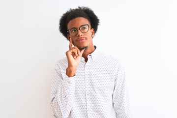 Young african american man wearing elegant shirt and glasses over isolated white background with hand on chin thinking about question, pensive expression. Smiling with thoughtful face. Doubt concept.