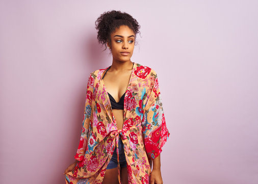 Young beautiful african american woman on vacation standing wearing bikini and colorful caftan