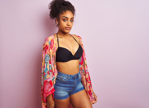 Young beautiful african american woman on vacation standing wearing bikini and colorful caftan