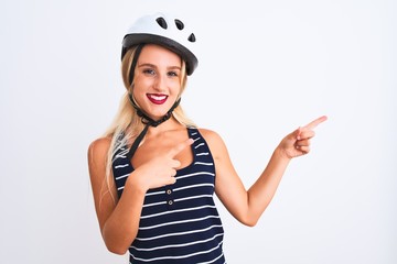 Young beautiful woman wearing bike helmet standing over isolated white background smiling and looking at the camera pointing with two hands and fingers to the side.