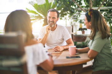 Obraz premium Beautiful family sitting on terrace drinking cup of coffee speaking and smiling