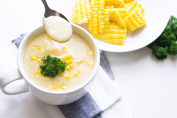 Corn soup in white bowl and sweet corn on plate, and copy space.
