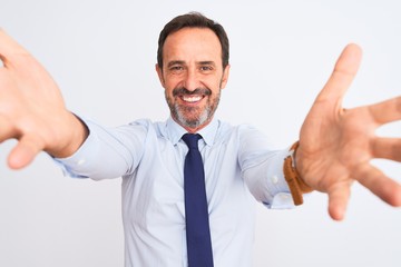 Middle age businessman wearing elegant tie standing over isolated white background looking at the camera smiling with open arms for hug. Cheerful expression embracing happiness.