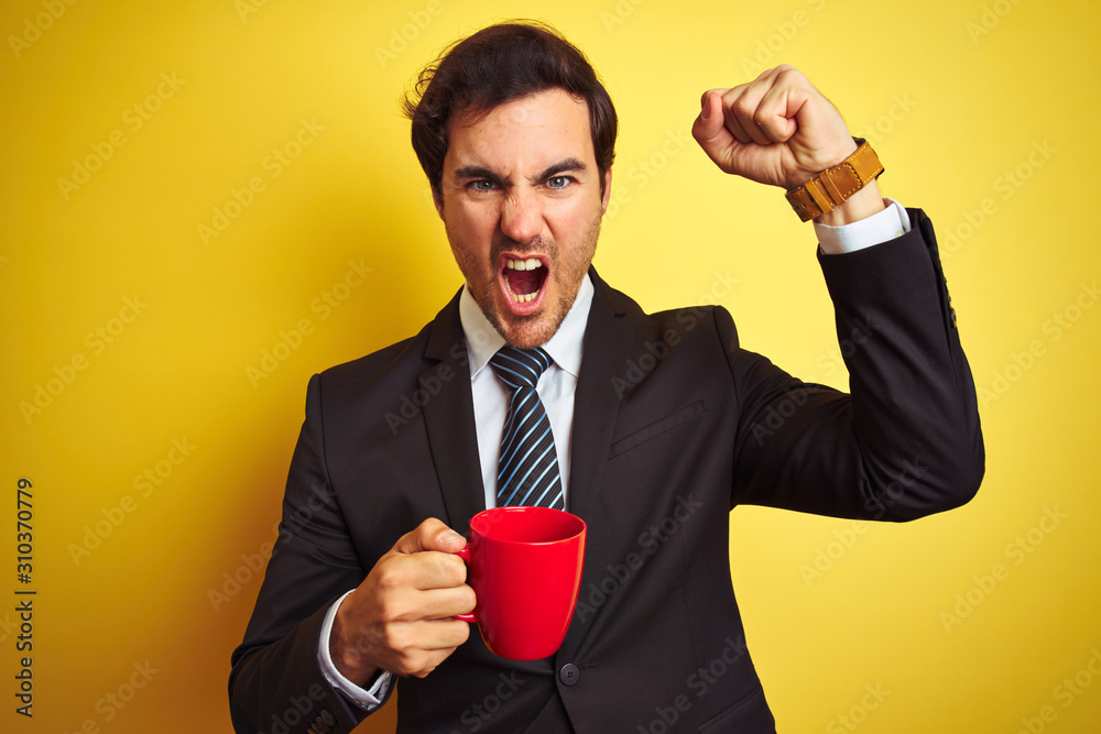 Sticker Young handsome businessman drinking red cup of coffee over isolated yellow background annoyed and frustrated shouting with anger, crazy and yelling with raised hand, anger concept