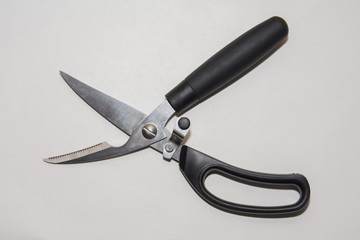 Top View Of Metal Multipurpose Kitchen Scissors with black plactics handles On White background. For cutting fish or chicken.