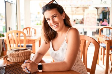 Young beautiful woman sitting at restaurant enjoying summer vacation