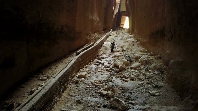 Man hiking thru the darkness in Vespasianus Titus Tunnel, Antakya
