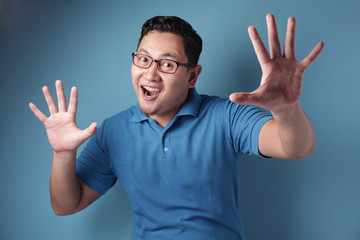 Naklejka premium Happy man smiling and shows palm up, excited surprised gesture