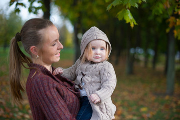 mother with child in the autumn forest for a walk