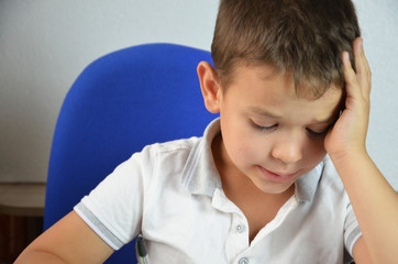 A child of primary school age do homework. The boy does his homework at his desk at home. The student pupil has been bored on the lesson. Back to school. Lovely first grader.