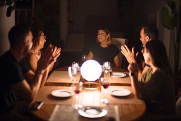Beautiful family on dinner applauding and smiling at terrace