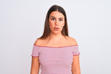 Portrait of beautiful young woman standing over isolated white background Relaxed with serious expression on face. Simple and natural looking at the camera.