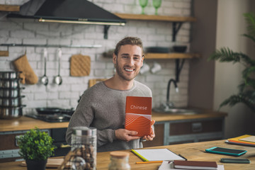 Young handsome man holding Chinese grammar book