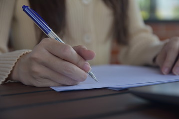 Close up women hand writing on document