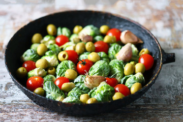 Brussels sprouts with vegetables and herbs in a pan. Cooking Brussels sprouts. Vega food. Selective focus.