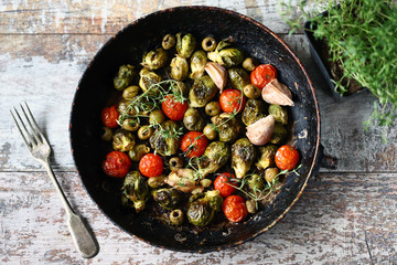 Brussels sprouts with vegetables and herbs in a pan. Cooking Brussels sprouts. Vega food. Selective focus.