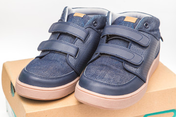 Children shoes sneakers on shoe cardboard box, isolate on white background.