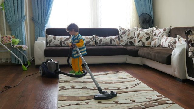 Small kid playing cleaning vacuum machine at home