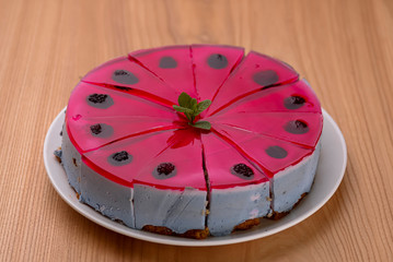 Pastry multi layered fruit yogurt cake. Cream and yogurt based fruit filling topped with jelly and raspberries.