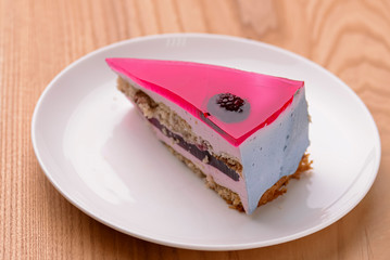Pastry multi layered fruit yogurt cake. Cream and yogurt based fruit filling topped with jelly and raspberries.