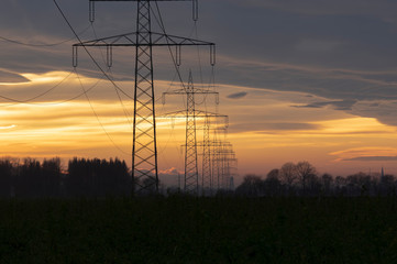 electricity pylons power line at orange sunset