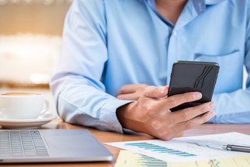Businessman is Reading News or Message on Smartphone while working at office