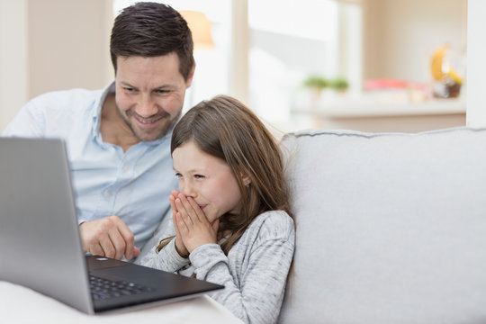 Father with daughter using laptop at home