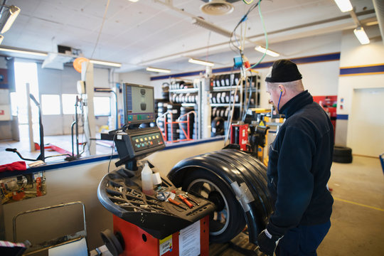 Man balancing the wheel in garage