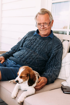 Man sitting with dog on sofa