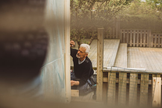 Senior Man Repairing Fence