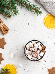 Fototapeta na wymiar Hot chocolate with marshmallows and cocoa powder. Frame of orange slices, fir tree branches, pullover and gingerbread cookies.White background, top view. Can be used as a christmas and new year card. 