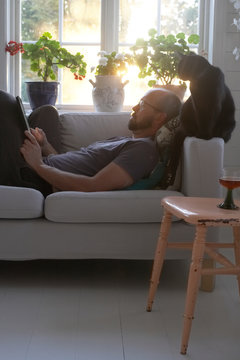 Man using tablet on sofa
