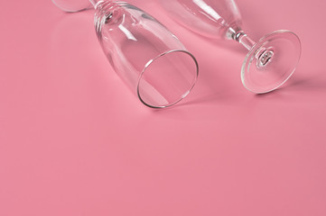 Two glasses for champagne lies on pink table on kitchen. Concept of celebrating. Space for text