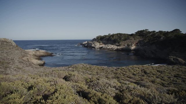 Panning shot of sunny ocean cove / Point Lobos, California, United States