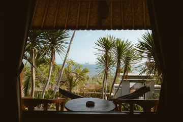 Relaxing view from the window on the palms and hammock in Bali