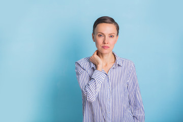 Portrait of a smart and beautiful young woman over light blue background wearing casual shirt and jeans