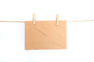 Old paper envelope hanging on rope on white background- Image