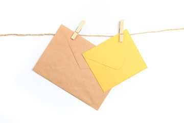 Old paper envelope hanging on rope on white background- Image